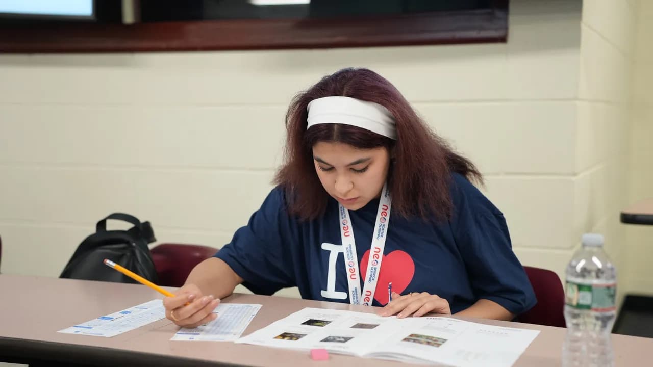 A student working through the paper at her desk