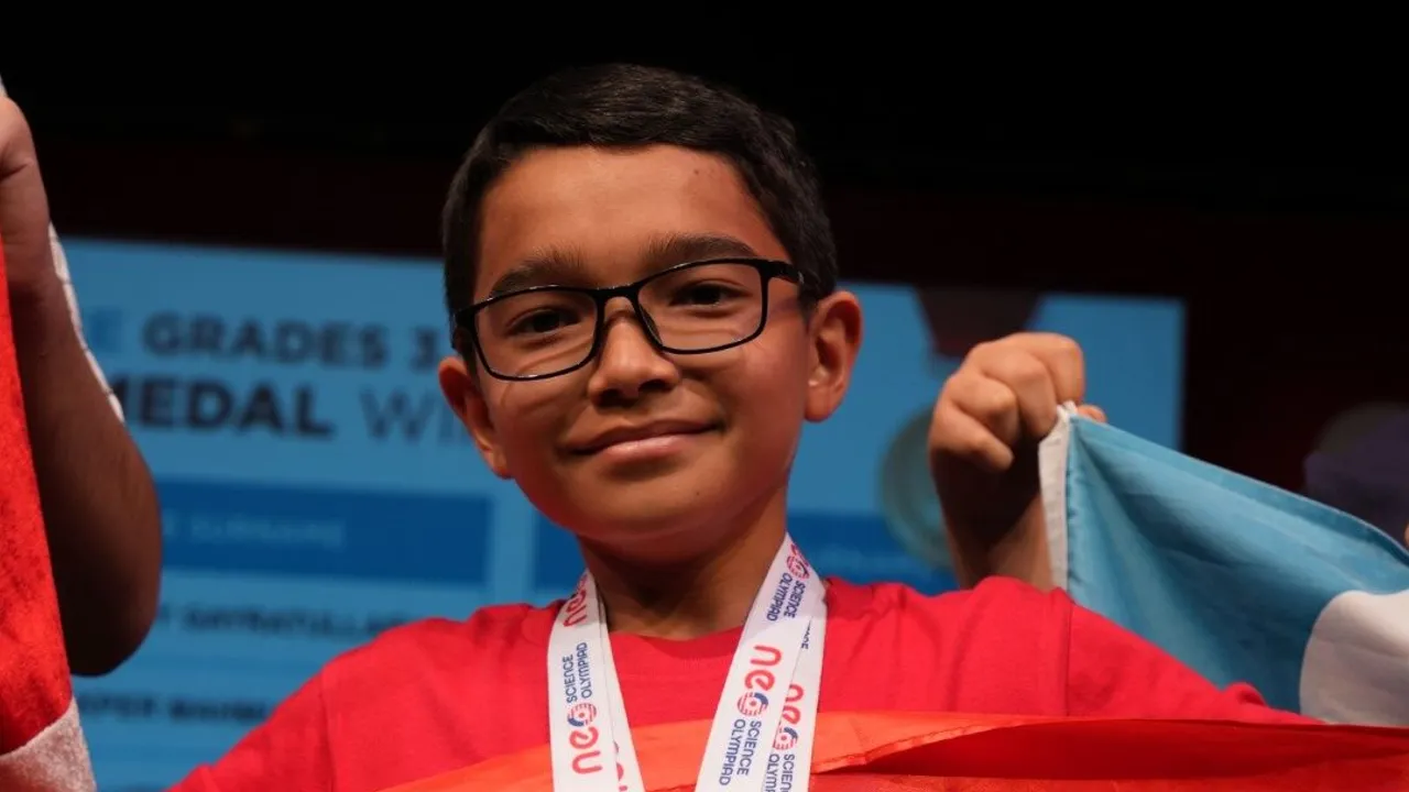 A medallist holding up the flag he competed under