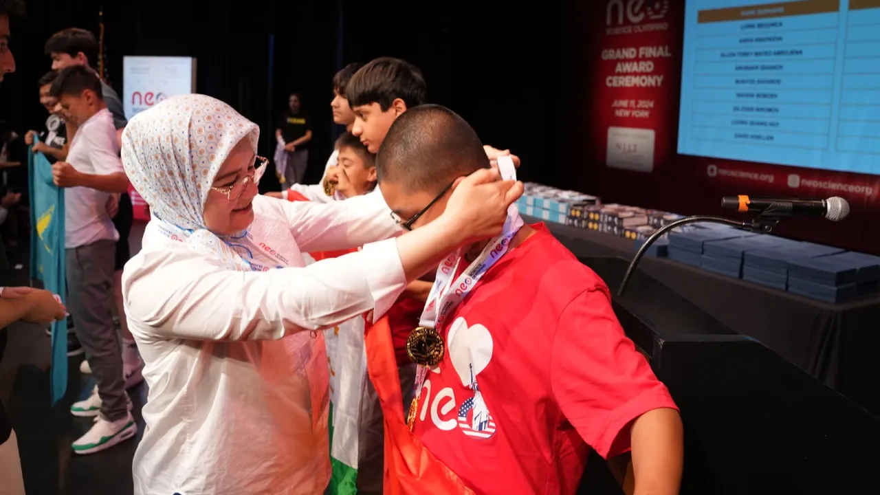 A parent placing a medal on a student at the ceremony